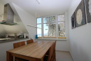 une cuisine avec une table en bois et une fenêtre dans l'établissement Stockmannsweg 14_ Whg_5 Haus am Me, à Wyk auf Föhr