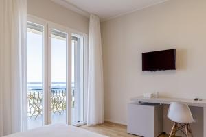 a bedroom with a bed and a desk with a television at TREROOMS B&B Gallipoli in Gallipoli