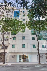 a tall white building with trees in front of it at Windsor Martinique Copacabana in Rio de Janeiro