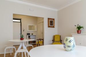 a room with a white bed and a table and chairs at TREROOMS B&B Gallipoli in Gallipoli