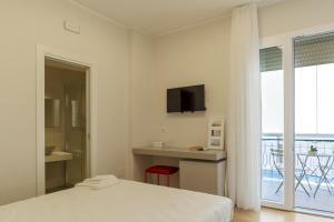 a white bedroom with a bed and a balcony at TREROOMS B&B Gallipoli in Gallipoli