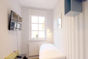 ein weißes Zimmer mit einem Bett und einem Fenster in der Unterkunft Kiek Ut 9, Whg. 3 in Wyk auf Föhr