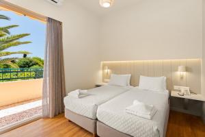 a bedroom with a bed and a large window at Lefktron Hotel in Stoupa