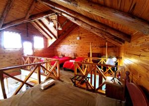 an attic room with red beds in a wooden cabin at Cabañas El Refugio de Puelo in Lago Puelo