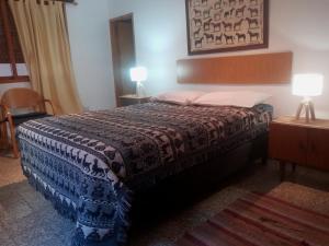 圣拉斐尔Casa Egea的一间卧室配有一张床和一张桌子上的两盏灯。