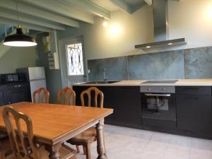 a kitchen with a wooden table and a table and chairs at ESCAPADE EN BAIE 3étoiles in Saint-Jean-le-Thomas