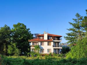 a large house with a red roof on a hill at Sirena condo 50 m from the central beach in Byala