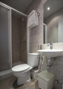 a bathroom with a toilet and a sink and a shower at Hostal Santa Isabel in Madrid