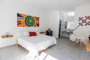 聖塔瑪麗亞德洛羅的住宿－Hotel Lucero Chan，卧室配有一张床,墙上挂有绘画作品