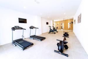 een fitnessruimte met loopbanden en hometrainers in een kamer bij Ibersol Siurell in Sa Coma