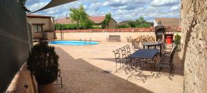 eine Terrasse mit einem Tisch, Stühlen und einem Pool in der Unterkunft Palacio de Velamazán in Velamazán