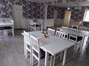 a white dining room with white tables and white chairs at Tamme Teemaja in Iisaku