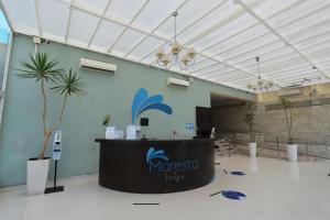 a large lobby with a counter and a palm tree at Hotel Maresta Lodge - Hotel Asociado Casa Andina in Chimbote