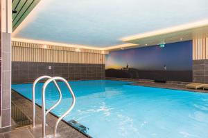 a large swimming pool in a hotel room at Bed & Breakfast Van Marion in Oostvoorne