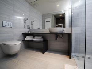 a bathroom with a sink and a toilet at Przystań Hotel&Spa in Olsztyn