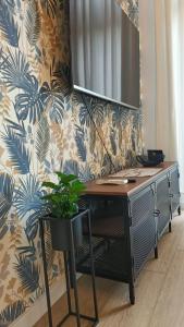 a desk in front of a wall with a plant at DROINVEST Apartament Zarembowicza WROCŁAW LOTNISKO AIRPORT - FV in Wrocław