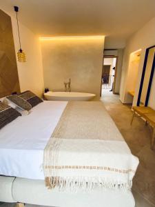 a bedroom with a large bed and a bath tub at VICTORIA - Adults Only by Ático73 in Medina Sidonia