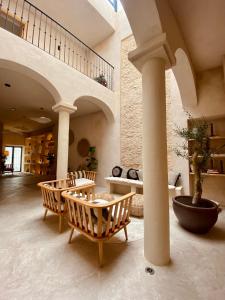 un vestíbulo con una mesa y sillas y una escalera en VICTORIA - Adults Only by Ático73 en Medina Sidonia