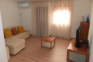 a living room with a couch and a television at Casa Das Eiras in Macedo de Cavaleiros