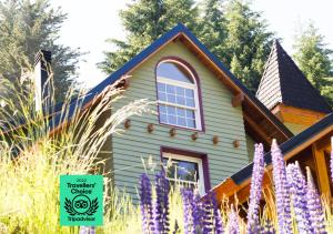 a house with purple flowers in front of it at Hostería Verde Morada in Villa La Angostura