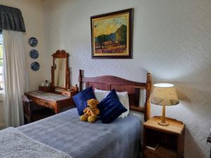 a teddy bear sitting on a bed in a bedroom at Mountain View Country Inn in Lady Grey