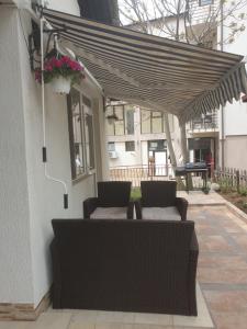 een patio met 2 stoelen en een luifel op een huis bij Villa Izgrev in Chernomorets