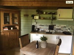 Eine Küche mit einem Holztisch, Stühlen und einer Theke in der Unterkunft B&B De Flecht - De Ljip in Nijega