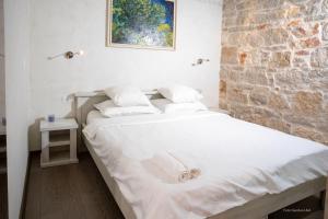 łóżko w pokoju z ceglaną ścianą w obiekcie Nata Apartment 4 stars w Rovinj