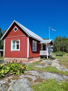 una casa roja con un banco delante en Saaristotila Jackois, en Iniö