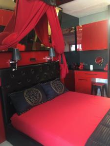 - une chambre avec un lit rouge et des armoires rouges dans l'établissement Rez de jardin OU ascenseur 4 ieme PISCINE -WIFI-Village naturiste holidaysochic, au Cap d'Agde