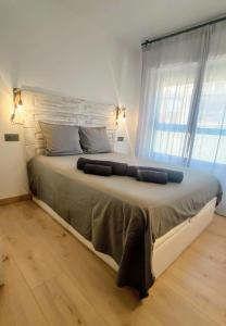 a large bed in a room with a large window at Aixopluc - Apartamento centro rio Ritort in Camprodon