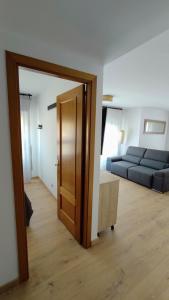 a open door to a living room with a couch at Aixopluc - Apartamento centro rio Ritort in Camprodon