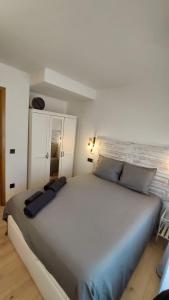 a large white bed with blue pillows in a room at Aixopluc - Camprodon Apartamento centro rio Ritort in Camprodon
