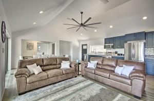 a living room with two brown couches and a kitchen at Waterfront Gravois Mills Home Deck and Grill! in Gravois Mills