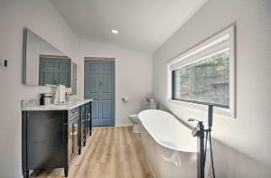 a bathroom with a tub and a sink and a window at Waterfront Escape Ozarks Home and Guest House! in Gravois Mills +32 photos