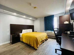 Habitación de hotel con cama con manta amarilla en Travelodge by Wyndham Brockville en Brockville