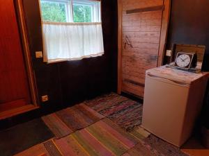 an empty room with a refrigerator and a window at Glamping Kotitila Kiveinen in Laitila