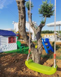 un'altalena intorno a un albero in un cortile di Case Vacanza Zeus a Trappeto