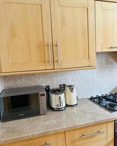 a kitchen counter with a microwave and a toaster at MODERN 2bed 2bath Ground Floor Apartment in Edinburgh