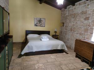 ein Schlafzimmer mit einem Bett und einer Steinmauer in der Unterkunft Donna Isabella in Conversano