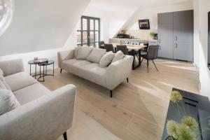 sala de estar con 2 sofás y comedor en Küsten Suite West seitliche Wasserlage, 1 Balkon, 90qm, en Greetsiel