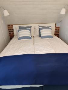 Una cama grande con almohadas azules y blancas. en Blue Haven Vendégház, Balatonfűzfő, en Balatonfűzfő