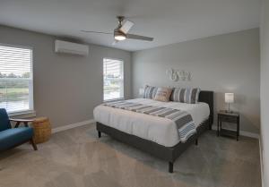a bedroom with a bed and a ceiling fan at Sea Swept Mermaid Oyhut Bay Seaside Village in Ocean Shores