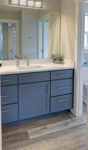 a bathroom with a blue sink and a mirror at Sea Swept Mermaid Oyhut Bay Seaside Village in Ocean Shores +50 photos