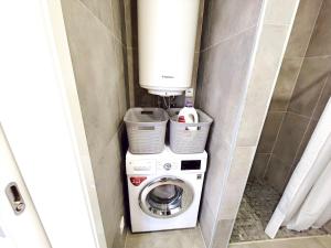 Waschmaschine und Trockner in einem kleinen Bad in der Unterkunft MF Terceira - Superior Boutique Studio in Praia da Vitória + 5 Fotos