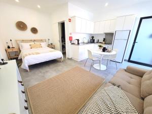 ein Wohnzimmer mit einem Bett und einer Küche in der Unterkunft MF Terceira - Superior Boutique Studio in Praia da Vitória
