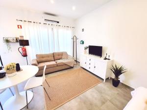 ein Wohnzimmer mit Sofa und Tisch in der Unterkunft MF Terceira - Superior Boutique Studio in Praia da Vitória