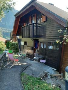 une maison avec des chaises, une table et un balcon dans l'établissement Châlet vue lac Léman à 1000 mètres d altitude, à Meillerie