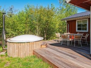 a deck with a hot tub and a table and chairs at 6 person holiday home in Hemmet in Hemmet