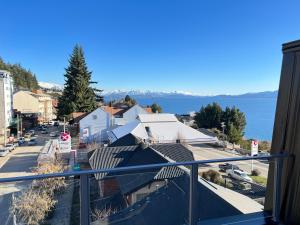 a balcony with a view of a town and the water at Acqua Apartments Bariloche in San Carlos de Bariloche